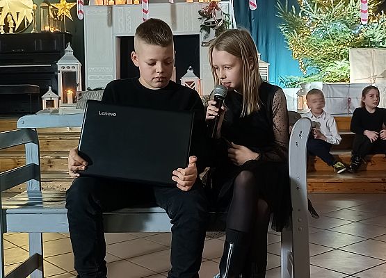 chłopiec z laptopem i dziewczynka siedzą na ławce