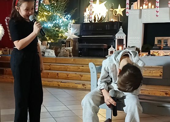 chłopiec siedzi ze spuszczoną głową i mówi do niego diabełek