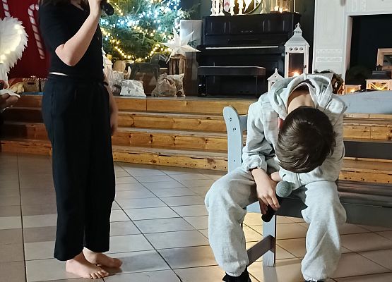 chłopiec siedzi ze spuszczoną głową i mówi do niego diabełek