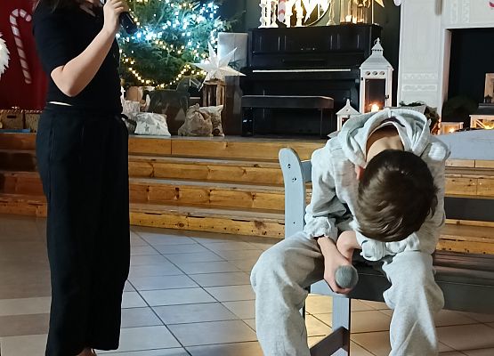 chłopiec siedzi ze spuszczoną głową i mówi do niego diabełek