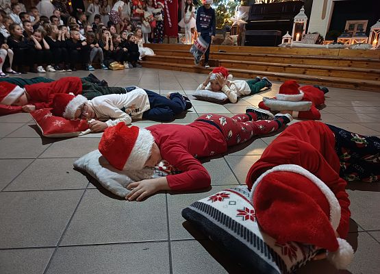dzieci w pidżamach leżą na poduszkach