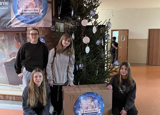 Uczniowie pozują do zdjęcia przy choince