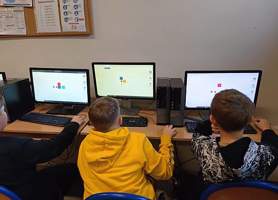 chłopcy podczas lekcji informatyki grają w grę logiczną