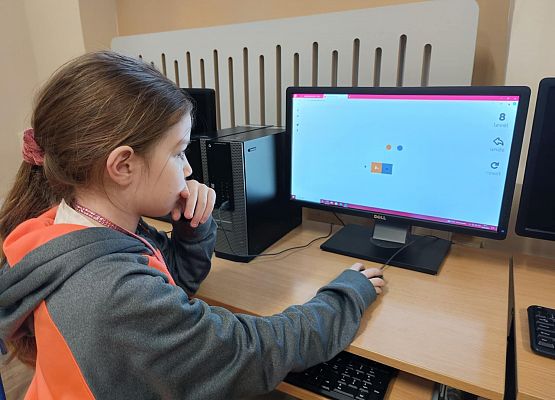 dziewczynka gra w grę logiczną na lekcji informatyki
