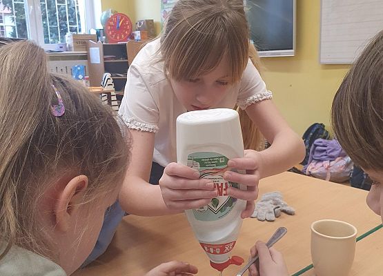 Uczennice przygotowują płyn do baniek