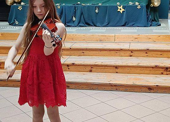 dziewczynka w czerwonej sukience gra na skrzypcach