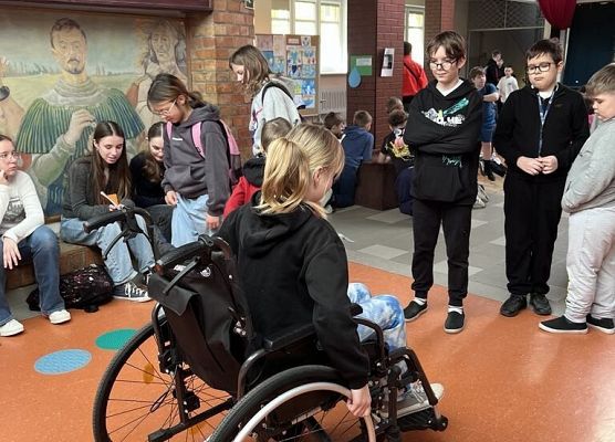 Uczennica siedź na wózku inwalidzkim.