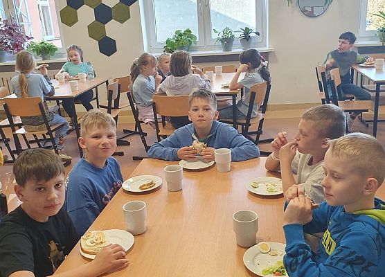 dzieci z apetytem jedzą śniadanie