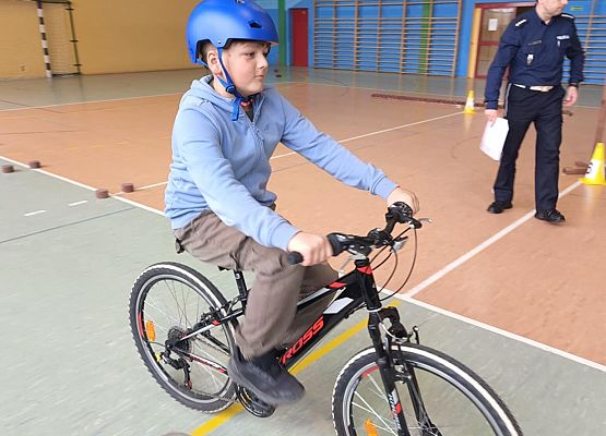 uczeń na rowerze w niebieskim kasku