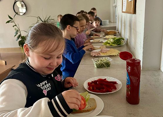 dzieci nakładają jedzenie na talerzyki