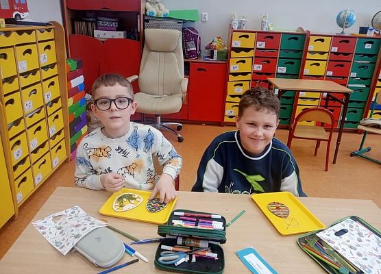 chłopcy ozdabiają pisanki