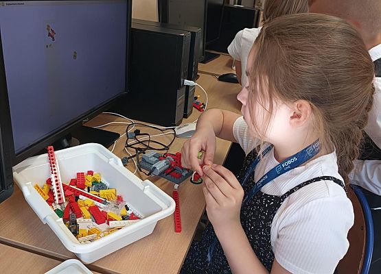 uczennica czyta instrukcję i buduje z klocków lego