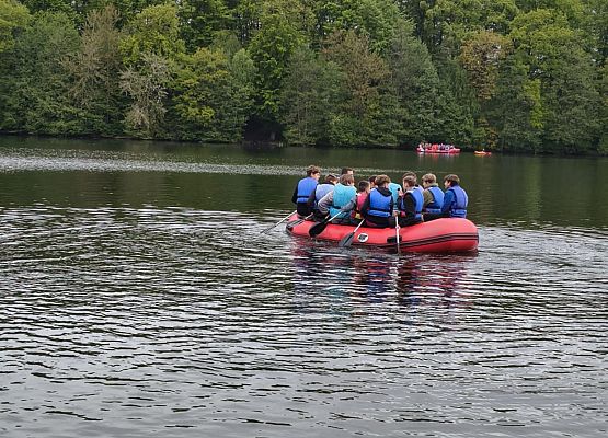 chłopcy płyną pontonem po jeziorze