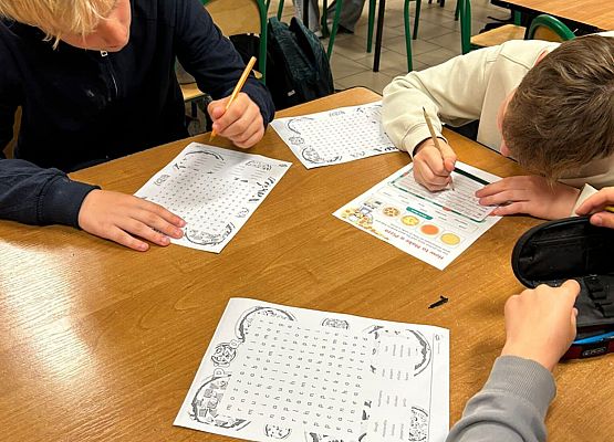 chłopcy uzupełniają karty pracy