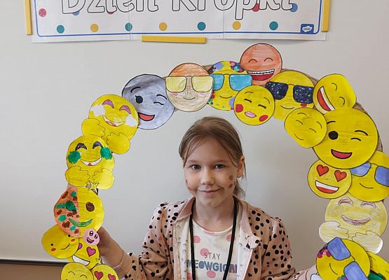 dziewczynka trzyma ramkę z emotikonami