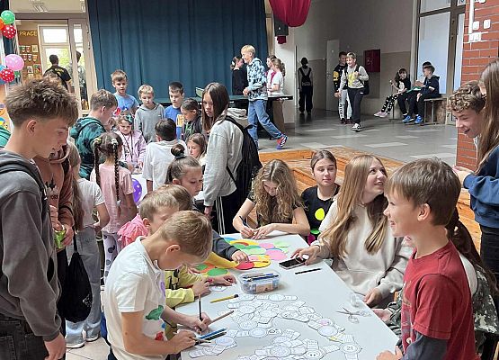 Uczniowie rysują przy dużym stoliku