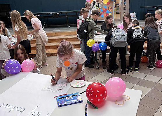 Na stole leży plakat Mój talent , uczniowie wpisują swoje talenty