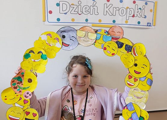 dziewczynka trzyma ramkę z emotikonami