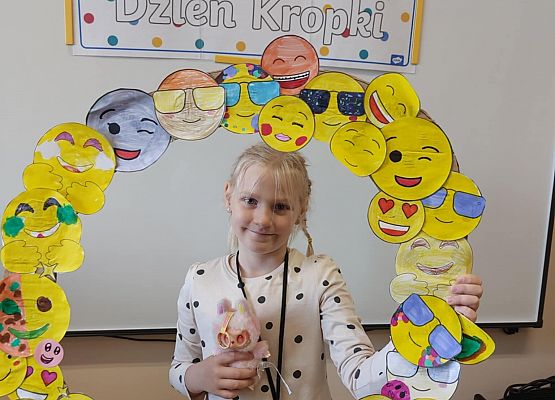dziewczynka trzyma ramkę z emotikonami