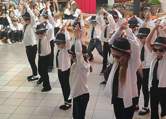 dzieci tańczą w czarnych kapeluszach