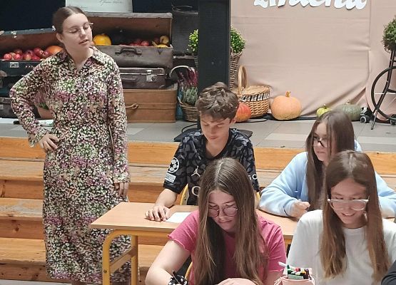 uczniowie siedzą w ławkach