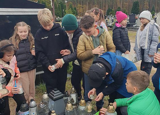 Uczniowie przy grobie byłych pracowników szkoły.