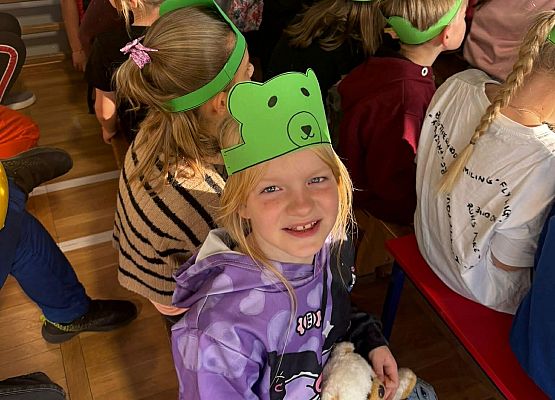 Uczniowie w wykonanych samodzielnie opaskach z misiem oglądają zmagania turniejowe