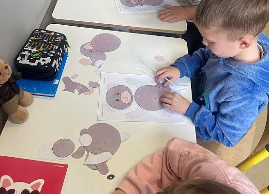 Uczniowie układają postać misia przy pomocy słomki