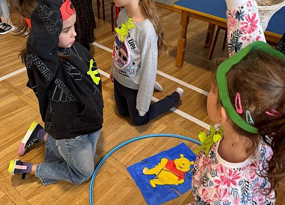 Uczniowie układają puzzle z misiem