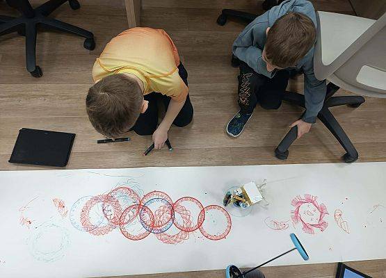 chłopcy malują robotem