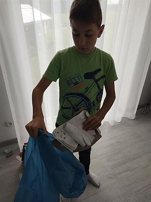 Michał wrzuca papier do niebieskiego worka