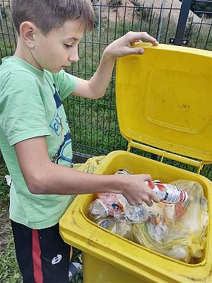 Tomek wrzuca plastik do żółtego worka